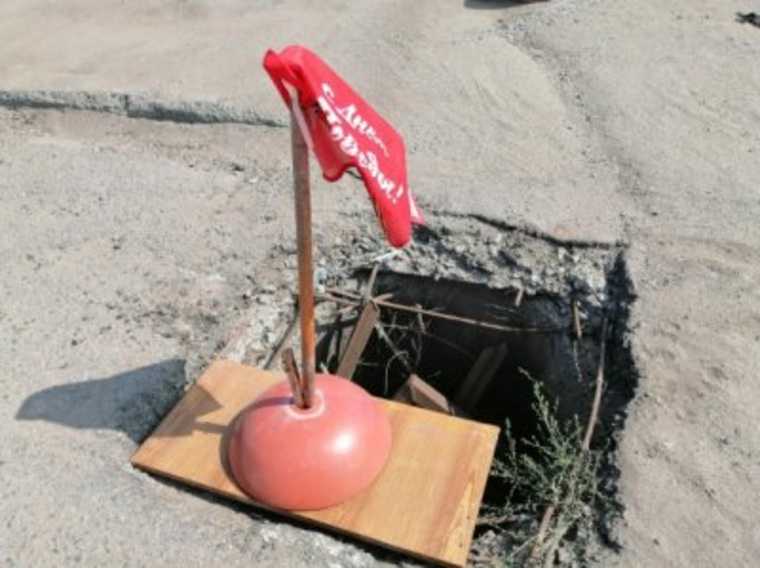 В Троицке яму на дороге прикрыли флажком ко Дню Победы. Фото